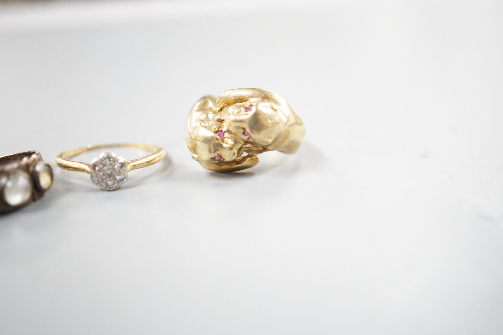 A modern 9ct gold and gem set twin leopards head ring, size S, gross 5.6 grams, a late Victorian 15ct gold and three stone moonstone ring, size M/N (shank cut), gross 3.3 grams and an 18ct and diamond cluster ring, size